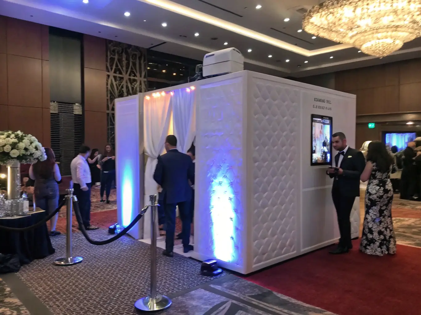 A vibrant photobooth setup with props and a backdrop, capturing guests having fun at a corporate event. The booth is equipped with modern technology and instant printing.