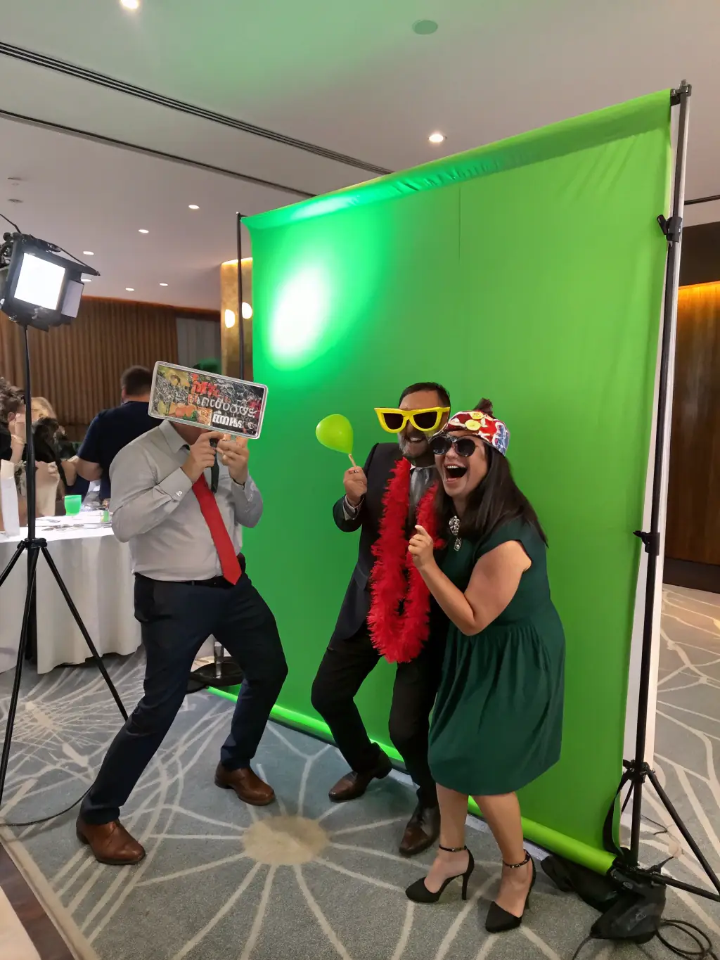 A modern open-air photobooth setup at a corporate event, capturing attendees with branded props and a custom backdrop, showcasing the interactive fun and brand integration.